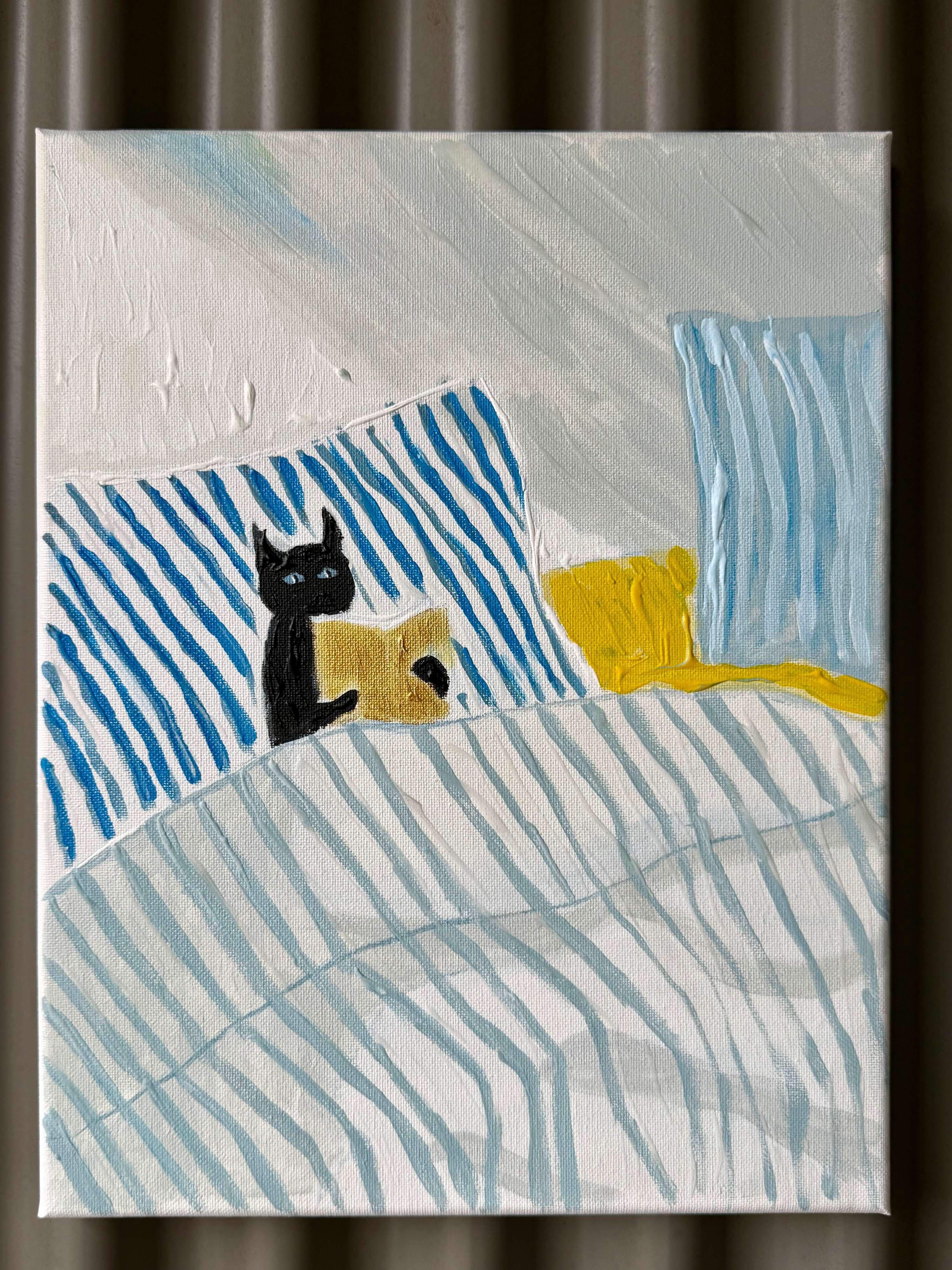 A cat in bed reading a book